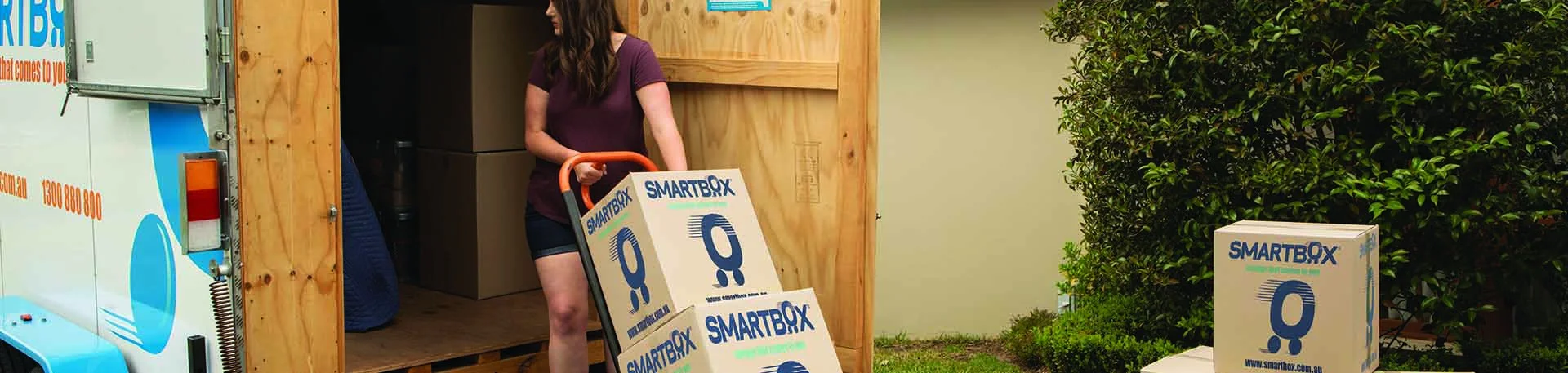 woman pulling a hand truck trolley with carton boxes